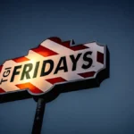 TGI Fridays sign lit against a darkening evening sky