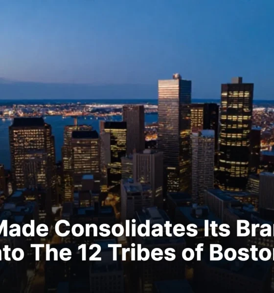 Downtown Boston at blue hour seen from above with lit buildings and the harbor.