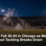 An empty NFL stadium field under floodlights on a cold October night.